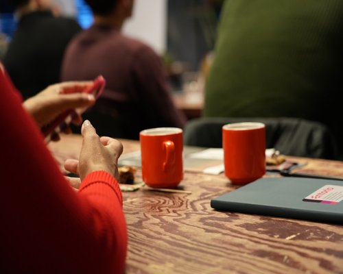 Hands holding a warm ceramic mug on a table
