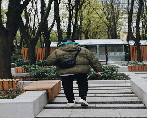 A person walking casually in an urban green park